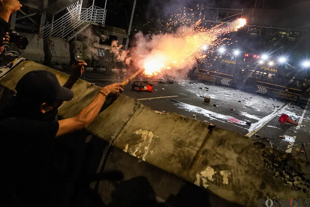 Massa aksi mulai melemparkan benda tumpul seperti batu dan menembakan kembang api ke arah polisi yang berjaga pada aksi unjuk rasa di sekitar Patung Arjuna Wijaya, Jakarta, 21 Februari 2025. (Sumber: Poskota/Bilal Nugraha Ginanjar)