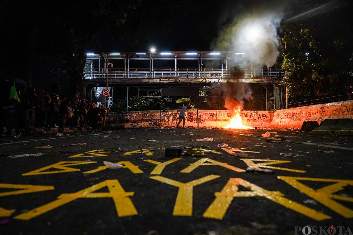 Massa aksi mulai melemparkan benda tumpul seperti batu dan menembakan kembang api ke arah polisi yang berjaga pada aksi unjuk rasa di sekitar Patung Arjuna Wijaya, Jakarta, 21 Februari 2025. (Sumber: Poskota/Bilal Nugraha Ginanjar)