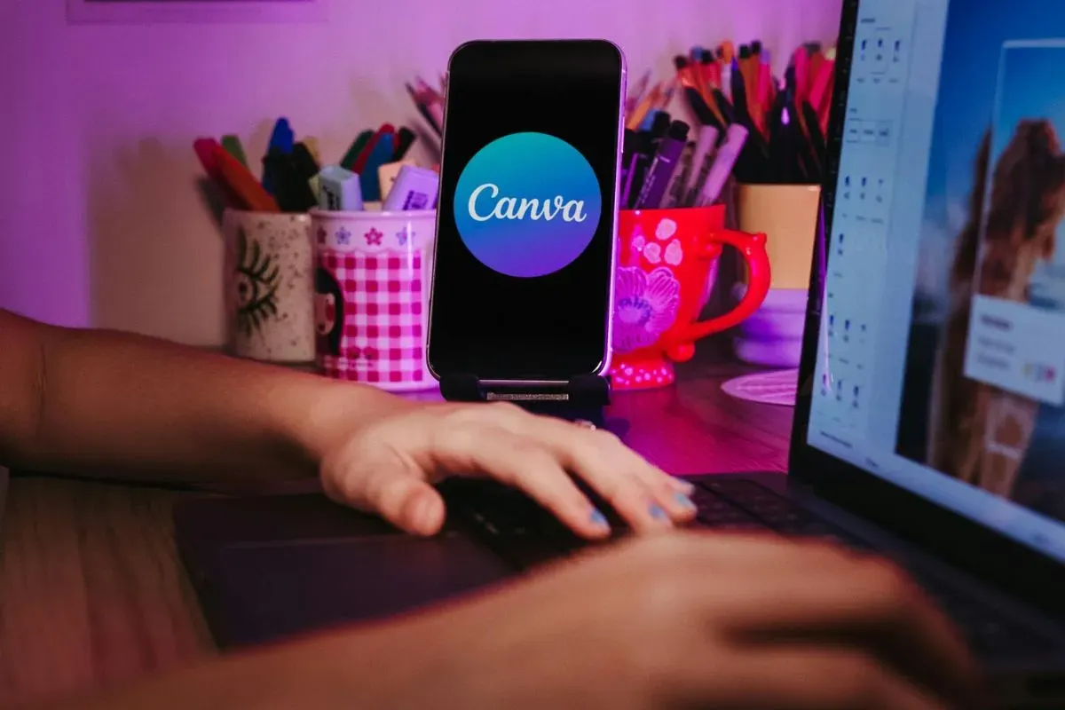 Tangan seseorang sedang melakukan desain di Canva. (Sumber: Pexels/Jonathan Borba)