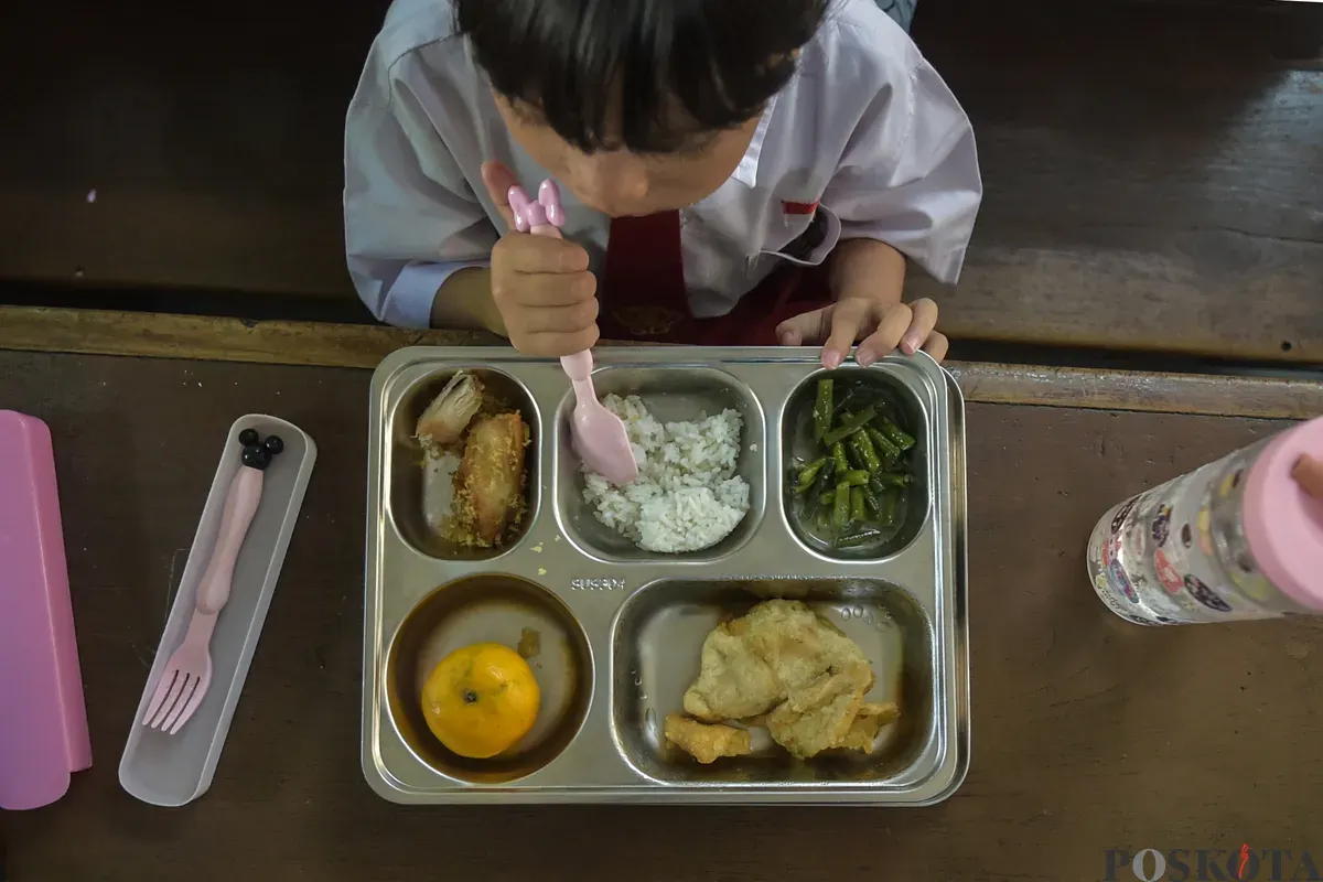 Sejumlah siswa menyantap menu makan siang dari program Makan Bergizi Gratis (MBG) Nasional di ruang kelas SDN Slipi 15, Jakarta Barat, Senin, 6 Januari 2025. (Sumber: Poskoata/ Bilal Nugraha Ginanjar)