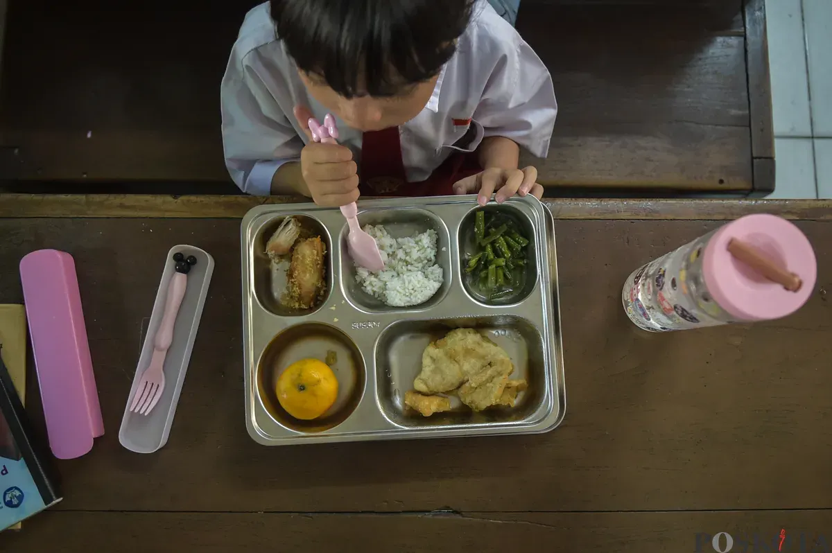 Siswa SDN Slipi 15 menyantap makanan dari program Makan Bergizi Gratis (MBG) Nasional di ruang kelas SDN Slipi 15, Jakarta Barat, Senin, 6 Januari 2025. (Poskota/ Bilal Nugraha Ginanjar)
