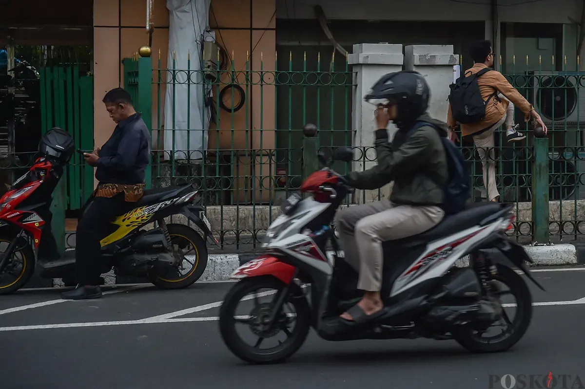 Sejumlah calon penumpang kereta api melompati pagar pembatas jalan raya dengan jalur pejalan kaki di kawasan Stasiun Cikini, Jakarta Pusat, Selasa, 7 Januari 2025.  (Poskota/ Bilal Nugraha Ginanjar) (Sumber: Poskoata/ Bilal Nugraha Ginanjar)