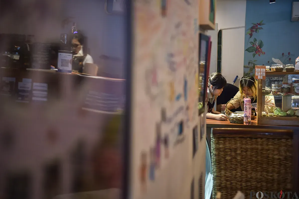 Wanita penyandang down Syndrome sekaligus berprofesi sebagai peracik kopi (Barista) ketika mengisi aktivitasnya mulai dari mempersiapkan, meracik hingga menyajikan minuman kopi pesanan pelanggannya di Kedai Kopi Kamu, Jakarta Selatan, Selasa, 7 Desember 2025. (Sumber: Poskoata/ Bilal Nugraha Ginanjar)