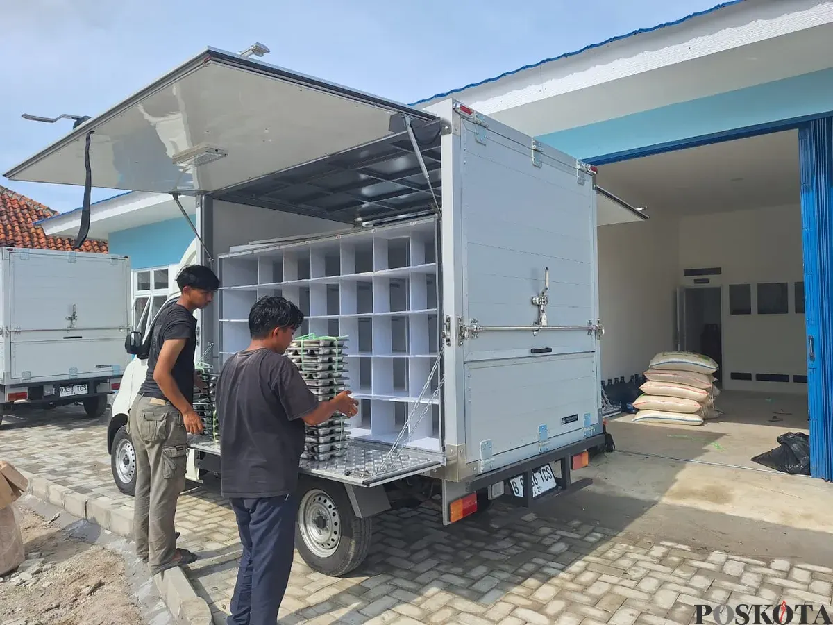 Rangga ujung kiri saat merapihkan wadah paket porsi makan bersama rekannya di depan dapur Makan Bergizi Gratis (MBG) di area halaman kantor Kecamatan Pebayuran, Kabupaten Bekasi, Jawa Barat, Selasa, 7 Januari 2025. (Sumber: Poskota/Ihsan Fahmi)