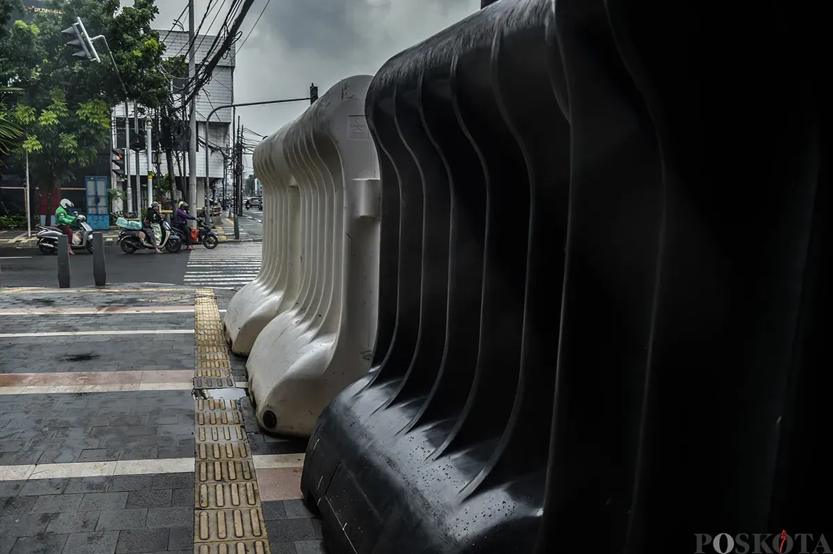 Deretan pembatas jalan tasblock yang melebihi tinggi badan orang dewasa yang tersimpan bukan pada tempatnya di trotoar Jalan Balikpapan, Gambir, Jakarta Pusat, Kamis, 9 Januari 2024. (Sumber: Poskota/ Bilal Nugraha Ginanjar)