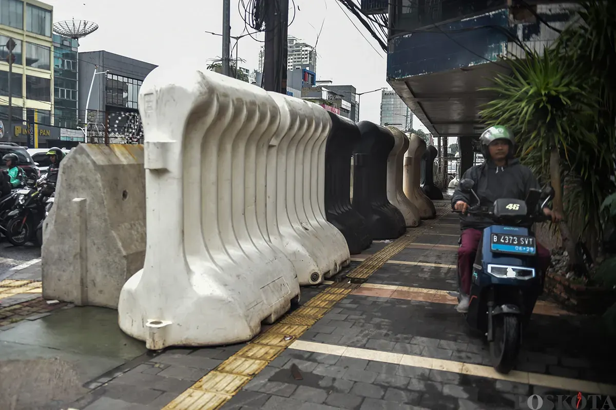 Deretan pembatas jalan tasblock yang melebihi tinggi badan orang dewasa yang tersimpan bukan pada tempatnya di trotoar Jalan Balikpapan, Gambir, Jakarta Pusat, Kamis, 9 Januari 2024. (Sumber: Poskota/ Bilal Nugraha Ginanjar)