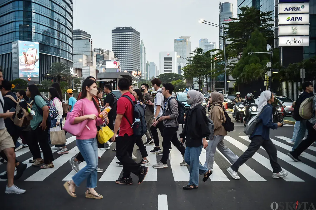 Para pekerja berjalan melintasi pedestrian sesaat setelah jam pulang kerja di kawasan Jalan Jenderal Sudirman, Jakarta, Jumat, 10 Januari 2025. (Sumber: Poskota/ Bilal Nugraha Ginanjar)