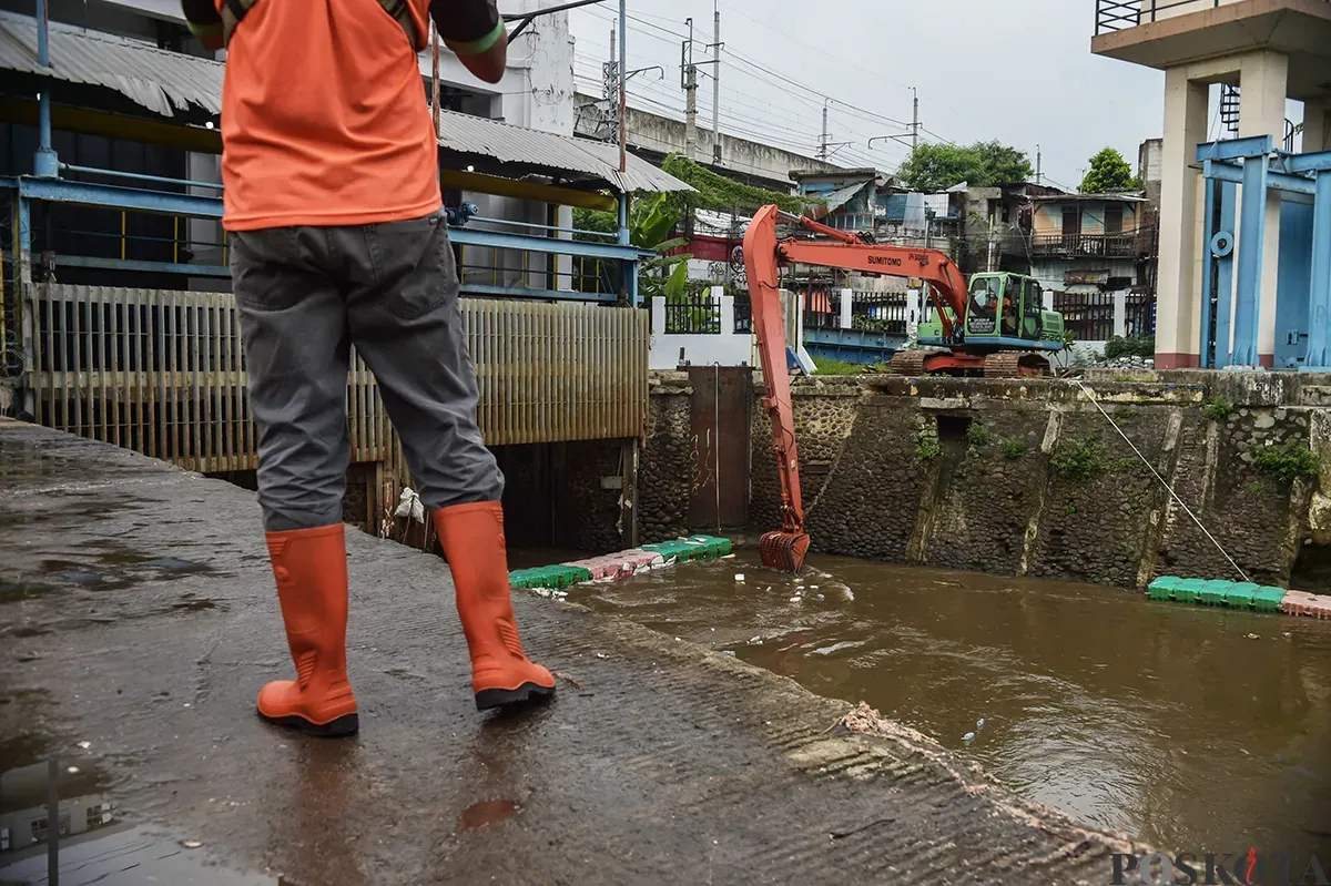 Alat berat membersihkan tumpukan sampah yang mengambang serta endapan sedimentasi di area Pintu Air Manggarai, Jakarta, Jumat, 10 Januari 2024. (Sumber: Poskota/ Bilal Nugraha Ginanjar)