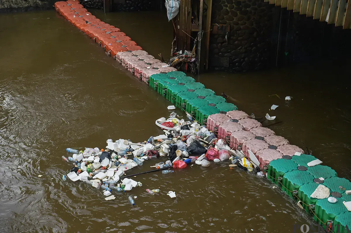 Alat berat membersihkan tumpukan sampah yang mengambang serta endapan sedimentasi di area Pintu Air Manggarai, Jakarta, Jumat, 10 Januari 2024. (Sumber: Poskota/ Bilal Nugraha Ginanjar)