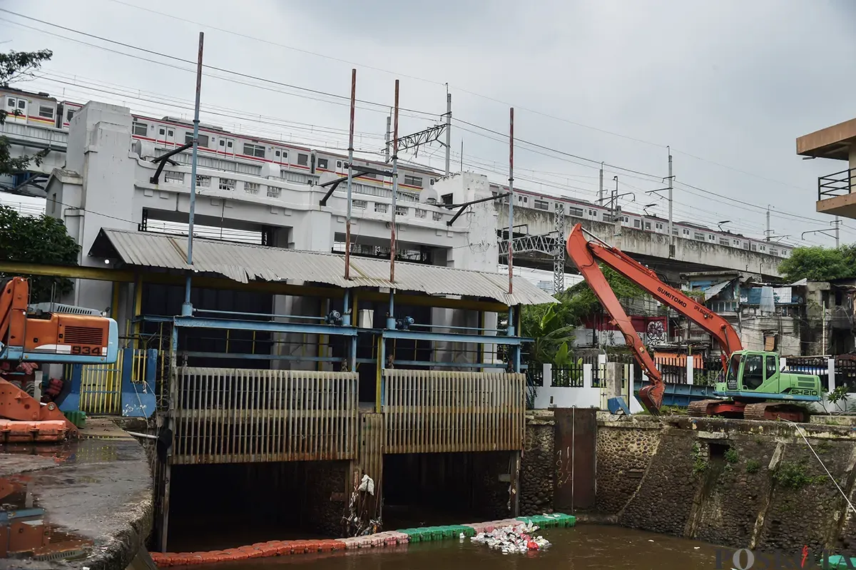 Alat berat membersihkan tumpukan sampah yang mengambang serta endapan sedimentasi di area Pintu Air Manggarai, Jakarta, Jumat, 10 Januari 2024. (Sumber: Poskota/ Bilal Nugraha Ginanjar)