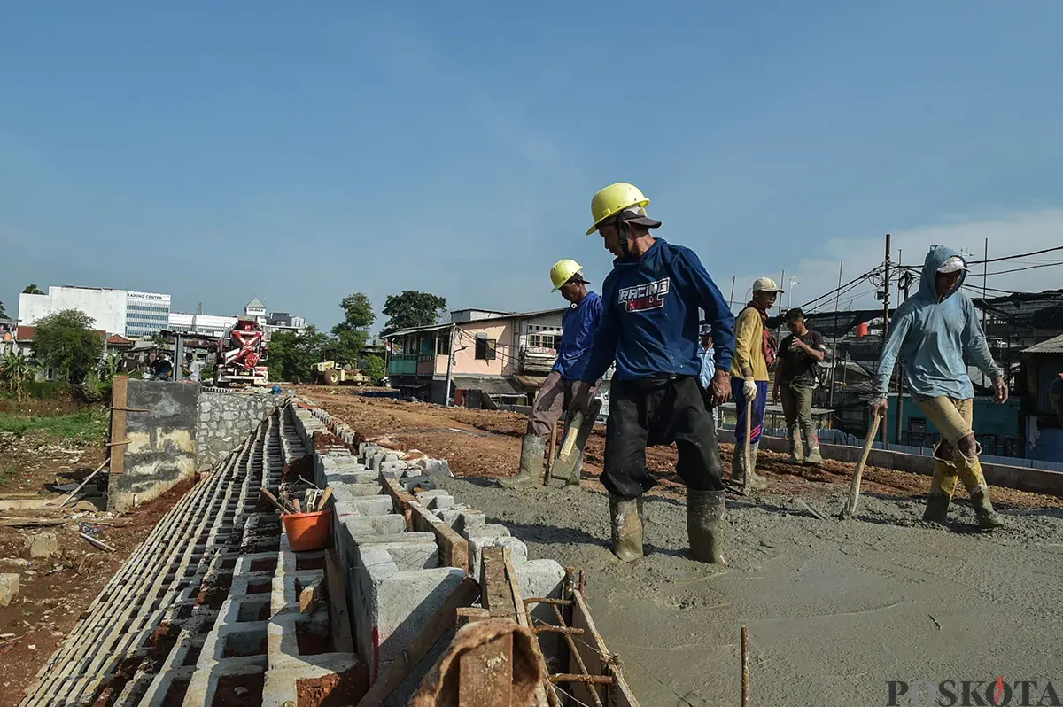 Sejumlah pekerja menyelesaikan pekerjaannya saat proses pembangunan dan pelebaran tanggul di bantaran aliran Sungai Ciliwung, Rawajati, Pancoran, Jakarta Selatan, Jumat, 10 Januari 2025. (Sumber: Poskota/ Bilal Nugraha Ginanjar)