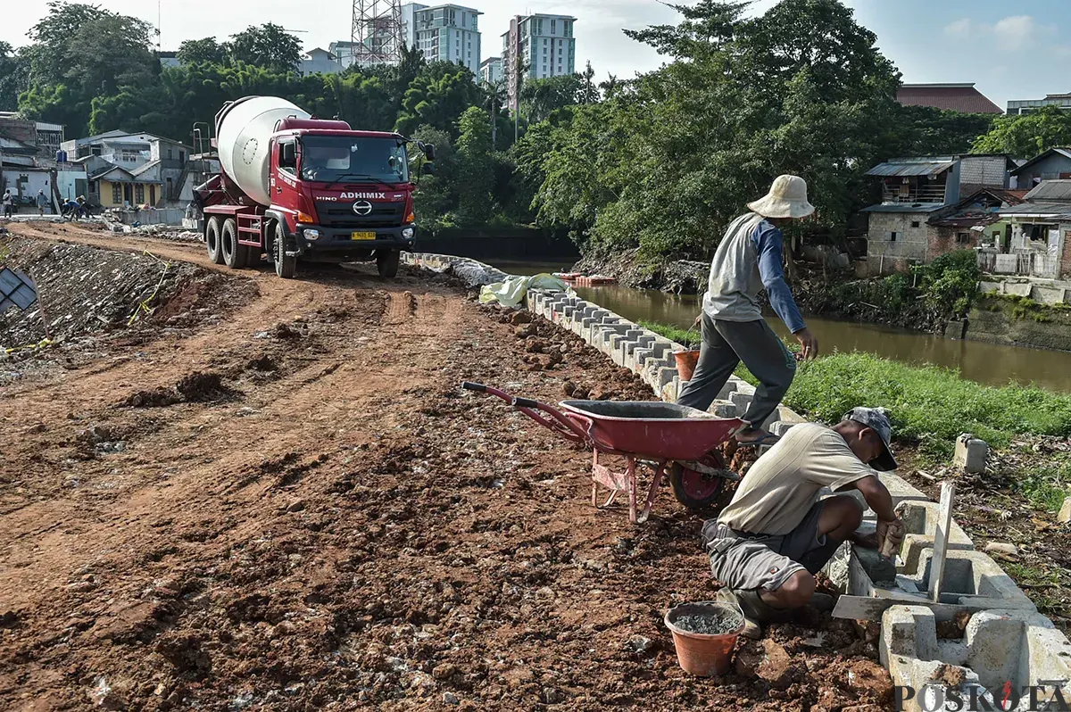 Sejumlah pekerja menyelesaikan pekerjaannya saat proses pembangunan dan pelebaran tanggul di bantaran aliran Sungai Ciliwung, Rawajati, Pancoran, Jakarta Selatan, Jumat, 10 Januari 2025. (Sumber: Poskota/ Bilal Nugraha Ginanjar)