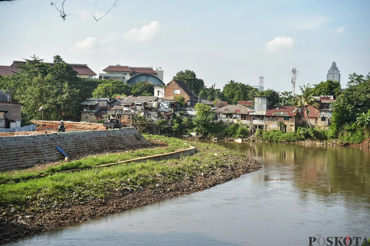 Sejumlah pekerja menyelesaikan pekerjaannya saat proses pembangunan dan pelebaran tanggul di bantaran aliran Sungai Ciliwung, Rawajati, Pancoran, Jakarta Selatan, Jumat, 10 Januari 2025. (Sumber: Poskota/ Bilal Nugraha Ginanjar)