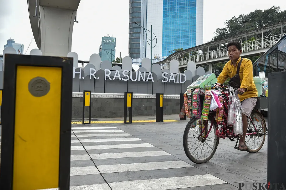 Warga melintas di trotoar Jalan Rasuna Said, Jakarta Selatan, Jumat, 10 Januari 2025. (Sumber: Poskota/ Bilal Nugraha Ginanjar)