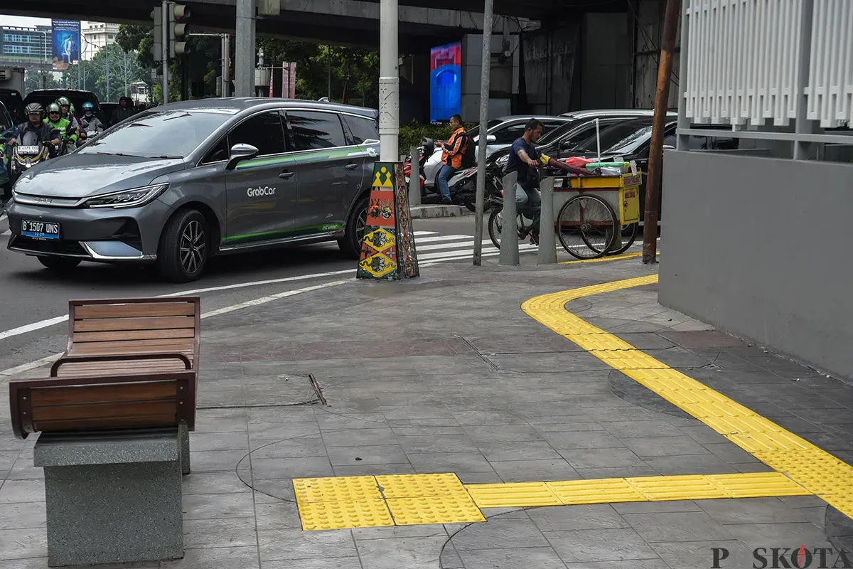 Warga melintas di trotoar Jalan Rasuna Said, Jakarta Selatan, Jumat, 10 Januari 2025. (Sumber: Poskota/ Bilal Nugraha Ginanjar)