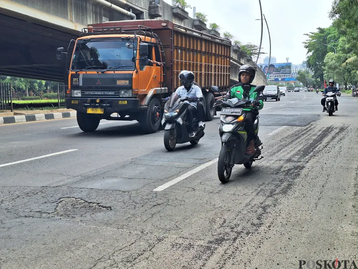 Pengendara motor terlihat hati-hati saat melintas di Jalan Ahmad Yani, Kota Bekasi dengan kondisi hamparan pasir dan penambalan lubang jalan. Sabtu, 11 Desember 2025. (Sumber: Poskota/Ihsan)