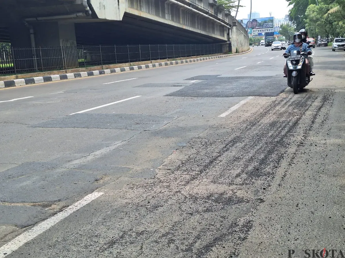 Pengendara motor terlihat hati-hati saat melintas di jalan Ahmad Yani, Kota Bekasi dengan kondisi hamparan pasir dan penambalan lubang jalan. Sabtu, 11 Desember 2025. (Sumber: Poskota/Ihsan)