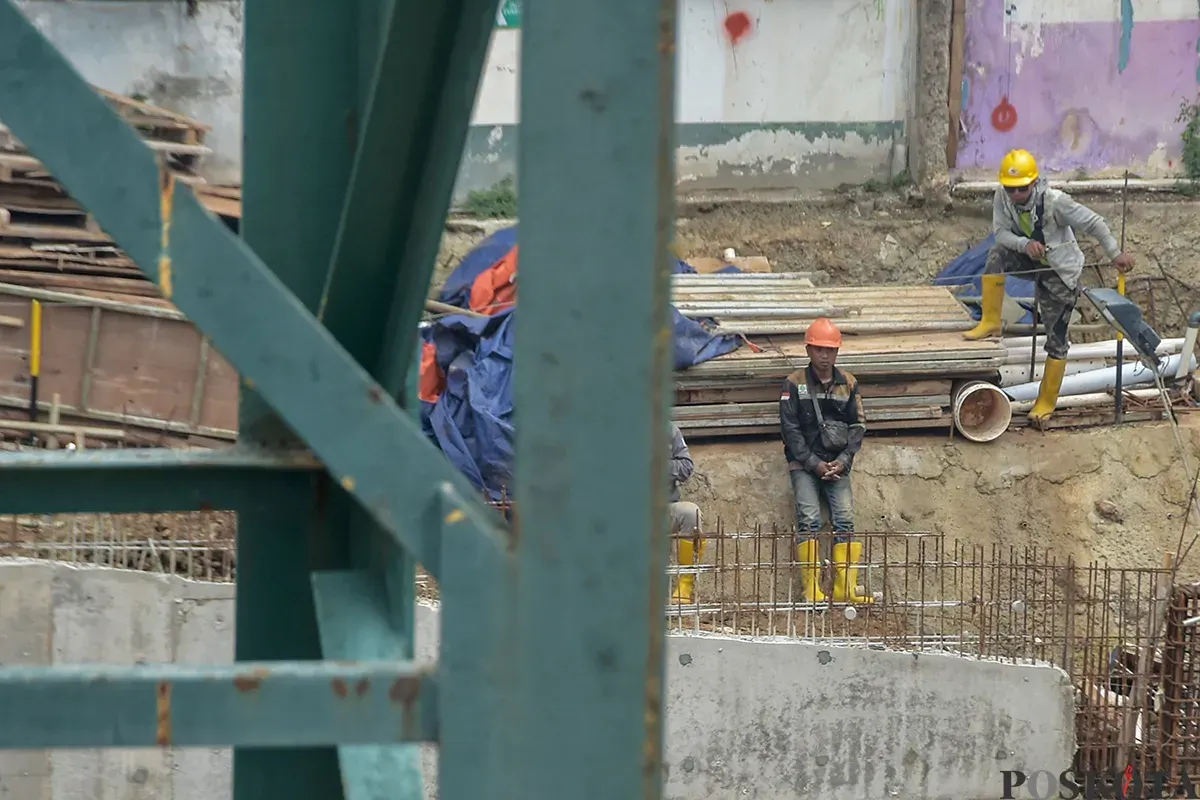 Pekerja menyelesaikan pembangunan proyek gedung di kawasan Slipi, Palmerah, Jakarta Barat, Sabtu, 11 Januari 2025. (Sumber: Poskota/Bilal Nugraha Ginanjar)