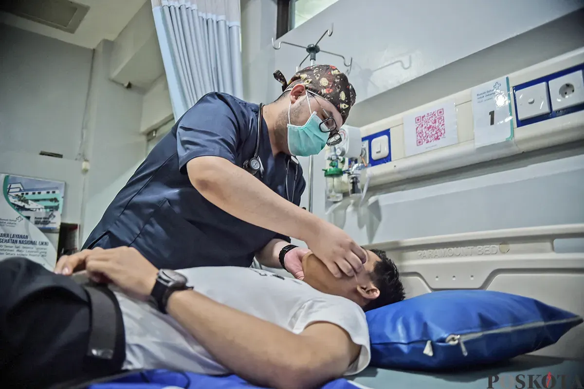 Seorang dokter memeriksa seorang pasien yang mengalami keluhan pernafasan di ruang pemeriksaan di Rumah Sakit Umum Daerah Tamansari, Jakarta Barat, Sabtu, 11 Januari 2024. (Sumber: Poskota/Bilal Nugraha Ginanjar)