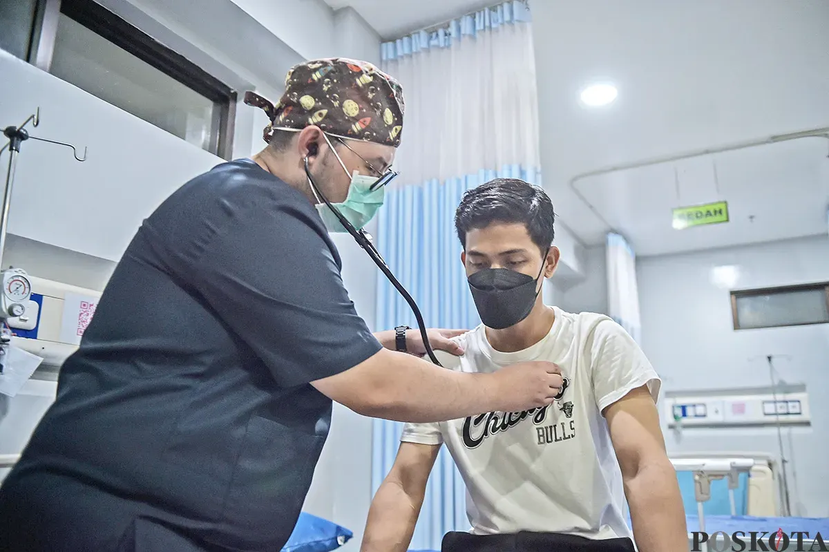 Seorang dokter memeriksa seorang pasien yang mengalami keluhan pernafasan di ruang pemeriksaan di Rumah Sakit Umum Daerah Tamansari, Jakarta Barat, Sabtu, 11 Januari 2024. (Sumber: Poskota/Bilal Nugraha Ginanjar)