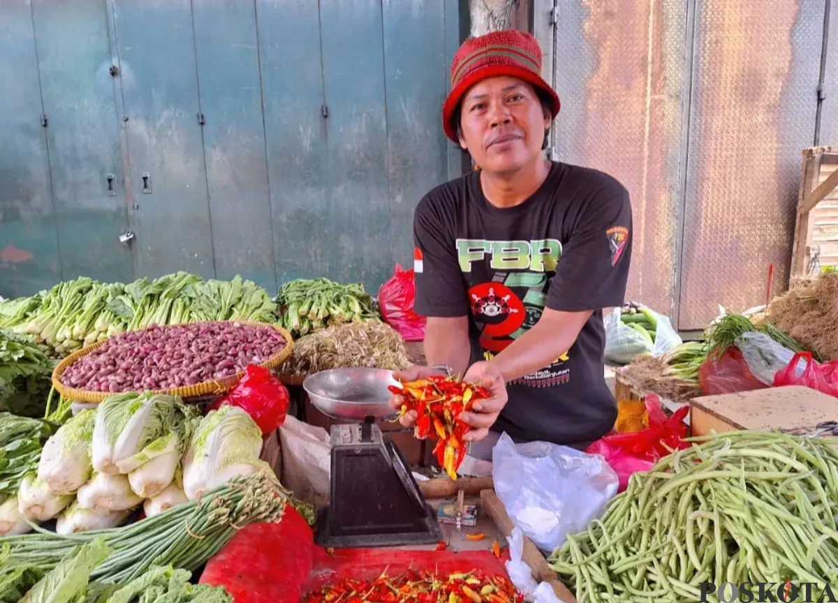 Pedagang sayur mayur di Pasar Baru Bekasi, bernama Uki, 40 tahun, saat memperlihatkan cabai yang kini tembus Rp120 ribu per kilogram. Minggu, 12 Januari 2025. (Sumber: Poskota/Ihsan)