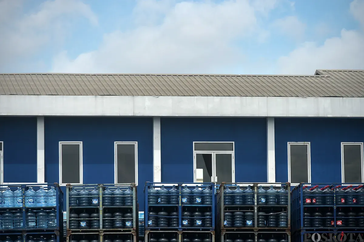 Pekerja memindahkan kemasan galon air mineral dengan alat berat di salah satu distributor air kemasan di kawasan depo air galon, Rawajati, Jakarta Selatan, Jum'at, 24 Januari 2025. (Sumber: Poskota/Bilal Nugraha Ginanjar)