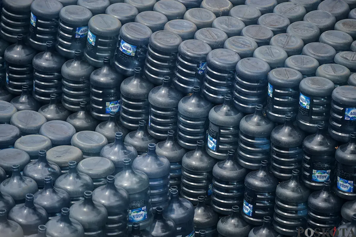 Pekerja memindahkan kemasan galon air mineral dengan alat berat di salah satu distributor air kemasan di kawasan depo air galon, Rawajati, Jakarta Selatan, Jum'at, 24 Januari 2025. (Sumber: Poskota/Bilal Nugraha Ginanjar)