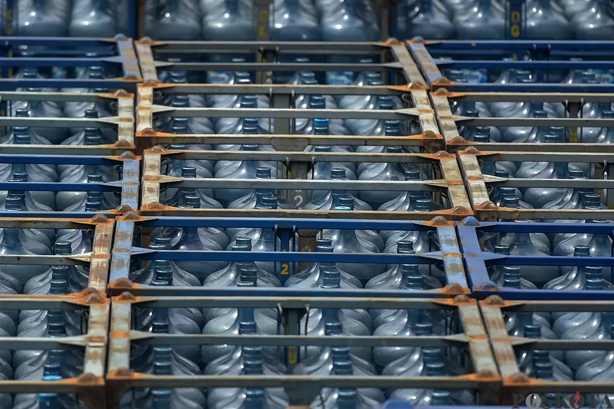 Pekerja memindahkan kemasan galon air mineral dengan alat berat di salah satu distributor air kemasan ternama di kawasan depo air galon, Rawajati, Jakarta Selatan, Jum'at, 24 Januari 2025. (Sumber: Poskota/Bilal Nugraha Ginanjar)