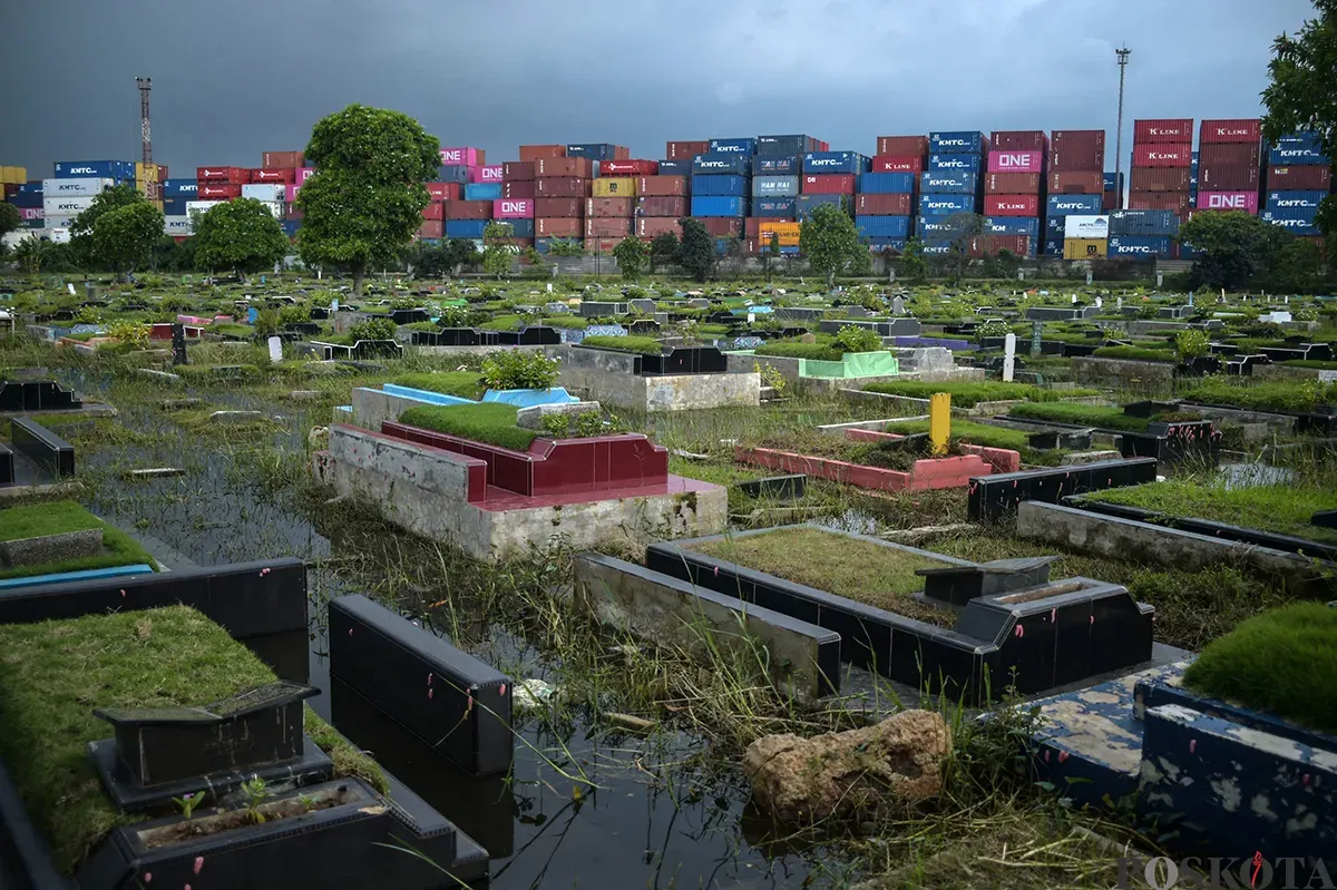 Warga berdoa di makam kerabat yang terendam air di Tempat Pemakaman Umum (TPU) Semper, Cilincing, Jakarta Utara, Jumat, 24 Januari, 2025. (Sumber: Poskota/Bilal Nugraha Ginanjar)