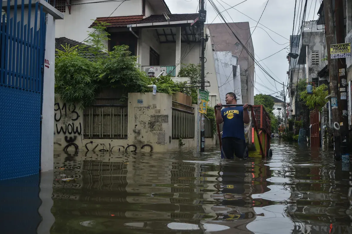 Ilustrasi warga melintasi jalan yang digenani banjir (Sumber: (Poskota/Bilal Nugraha Ginanjar)