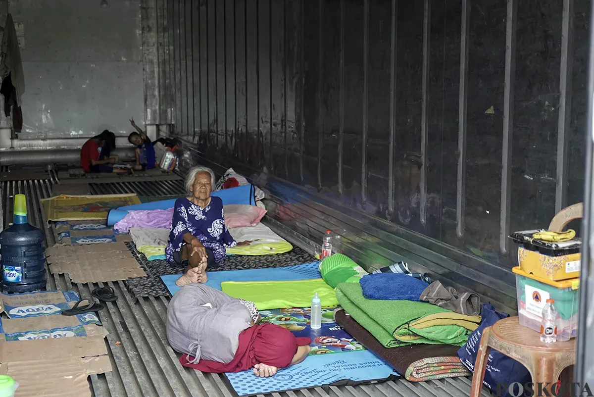 Sejumlah warga lanjut usia (lansia) dan keluarganya masih memilih bertahan di tempat pengungsian di dalam peti kemas kosong lantaran rumahnya masih terendam banjir dalam beberapa hari terakhir di Kelurahan Rorotan, Cilincing, Jakarta Utara, Jumat, 31 Januari 2025. (Sumber: Poskota/Bilal Nugraha Ginanjar)