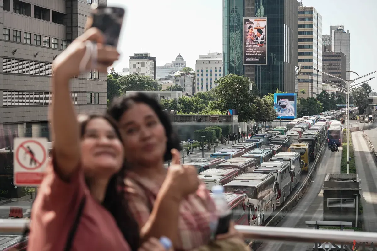 Sejumlah bus dan kendaraan bermotor memadati jalan lokasi acara perayaan HUT ke-79 Bhayangkara ke-79 di Jalan MH Thamrin dan Bundaran HI, Jakarta, Selasa, 1 Juli 2025. (Sumber: Poskota/Bilal Nugraha Ginanjar)