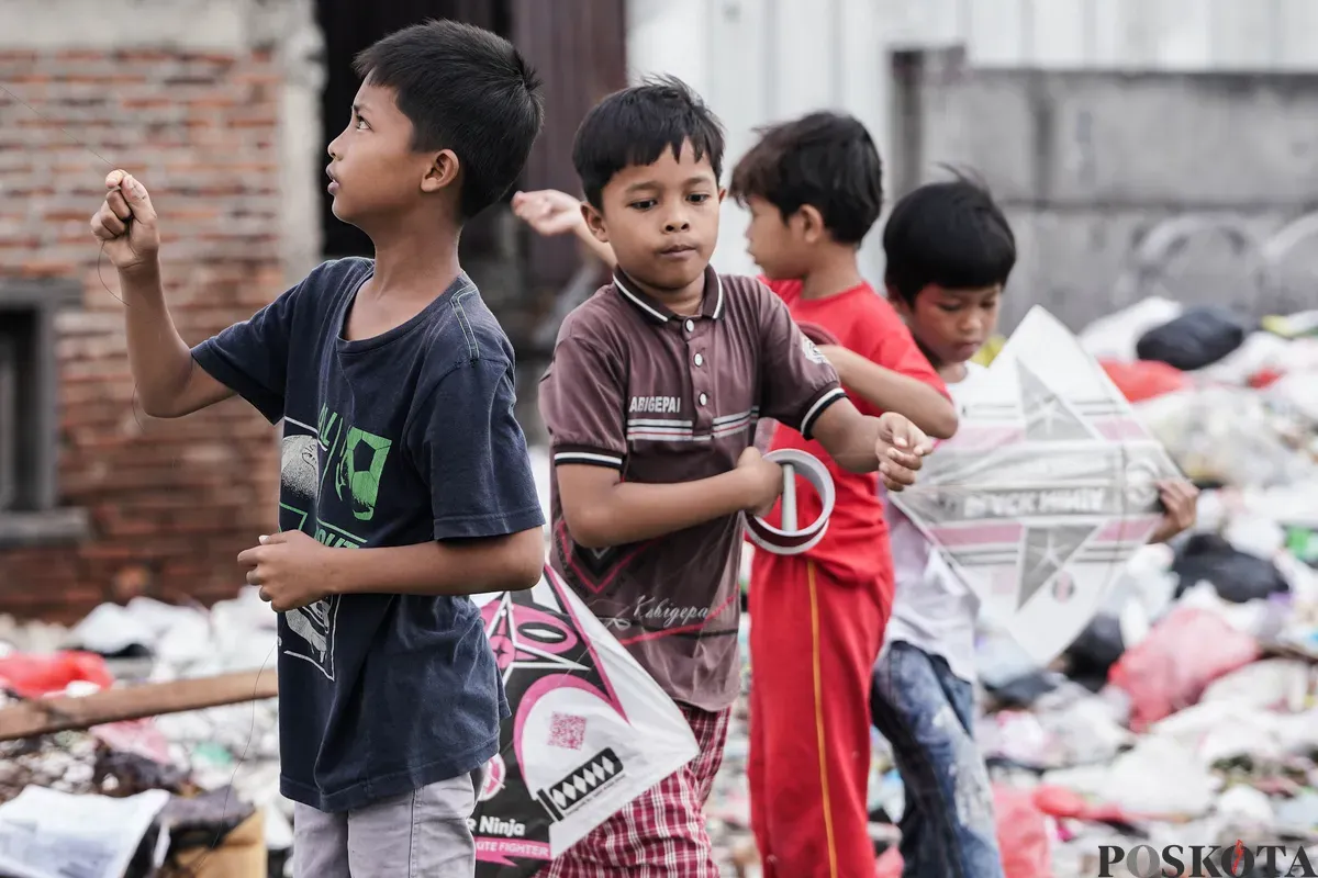 Anak-anak bermain layang-layang di lahan kosong, Kampung Boncos, Jakarta, 3 Juli 2025. (Sumber: Poskota/Bilal Nugraha Ginanjar)