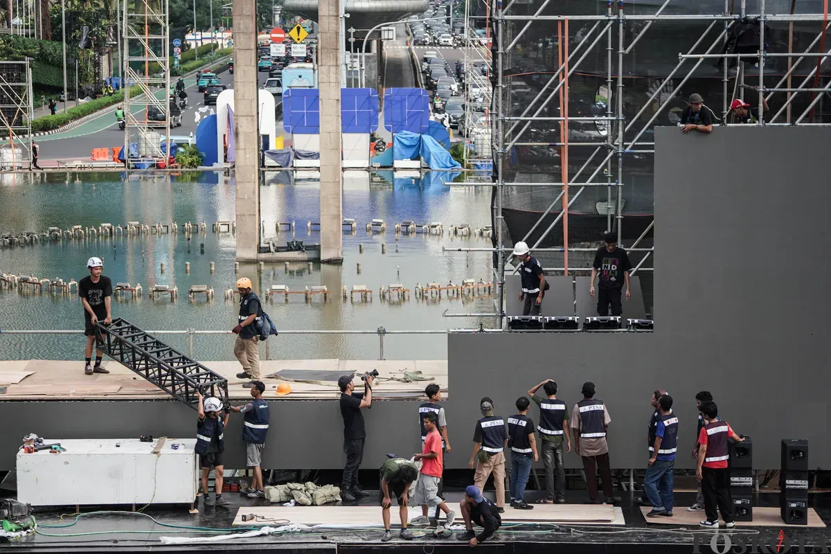Para pekerja menyelesaikan pembangunan panggung di kawasan Bundaran Hotel Indonesia (HI), Jakarta, Jumat, 4 Juli 2025. (Sumber: Poskota/Bilal Nugraha Ginanjar)