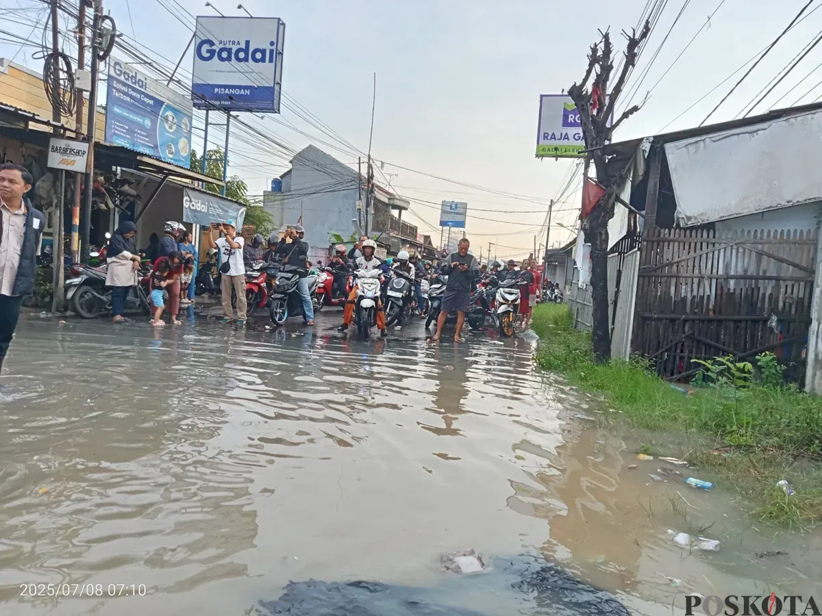 Jalan Raya Pisangan, Desa Satria Mekar, Kecamatan Tambun Utara, Kabupaten Bekasi, lumpuh total usai terendam banjir setinggi 50 sentimeter. Selasa, 8 Juli 2025. (Sumber: Poskota/Nurpini Aulia Rapika)