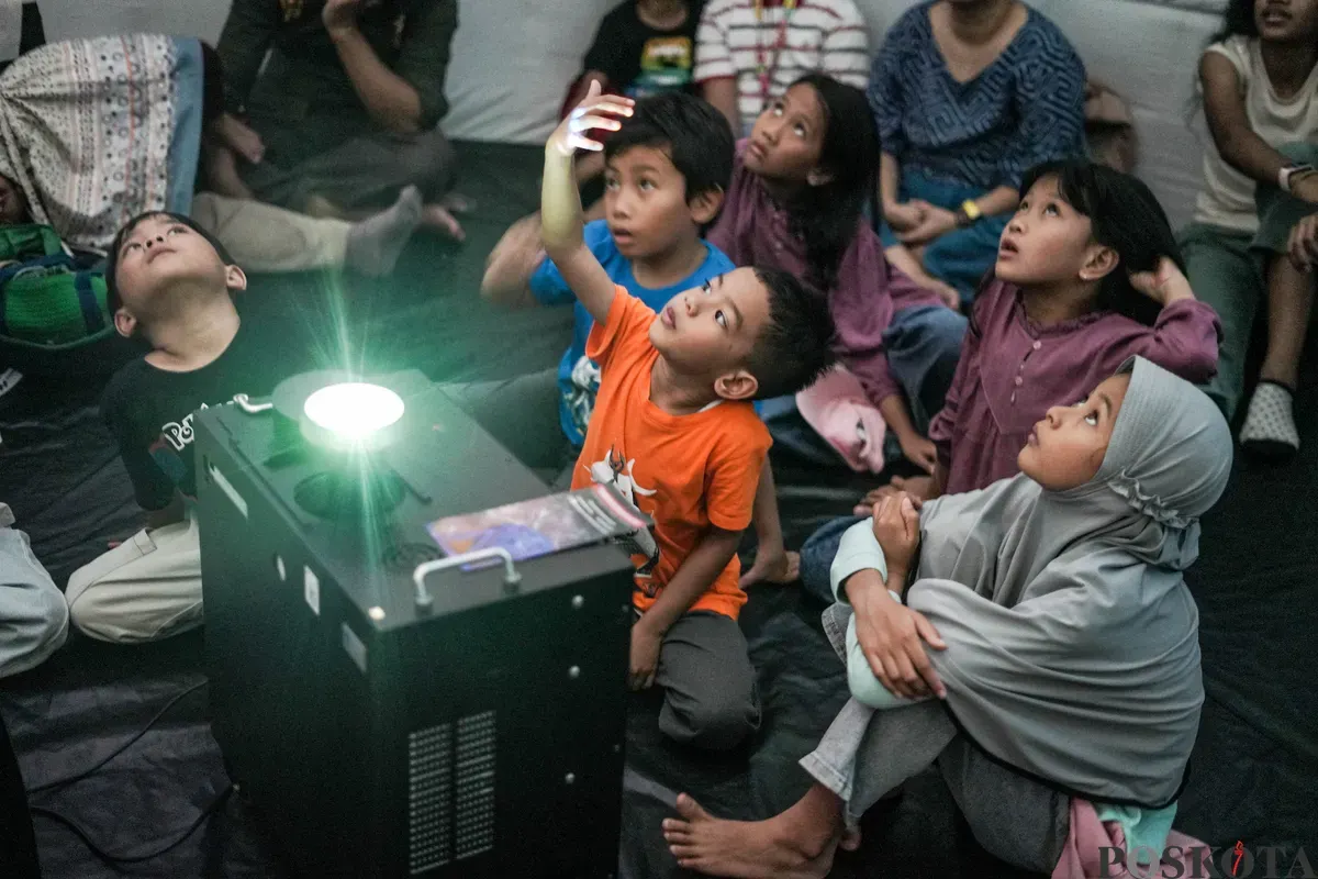 Anak-anak serta orang tuanya menyaksikan simulasi langit, serta penjelasan seputar astronomi di planetarium mini yang berlokasi di kawasan Taman Ismail Marzuki, Jakarta, Selasa 8, Juli 2025. (Sumber: Poskota/Bilal Nugraha Ginanjar)