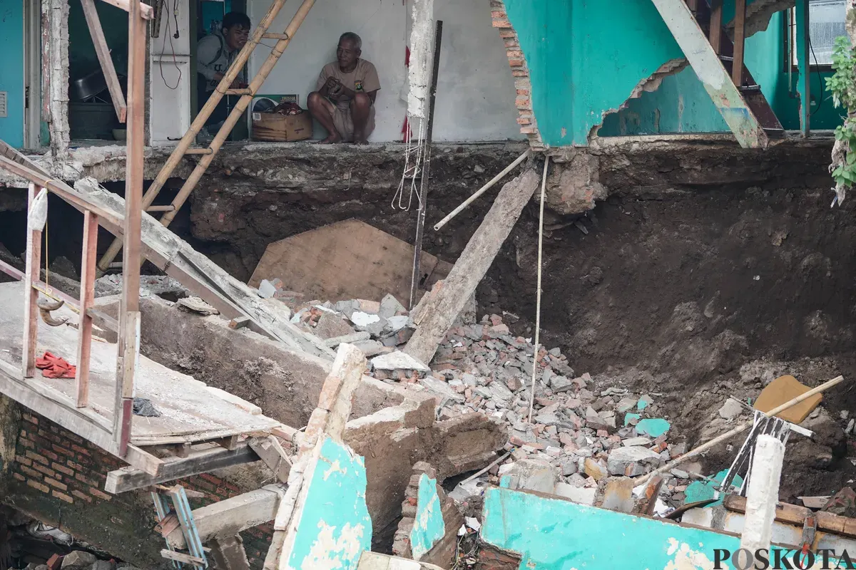 Warga melihat kondisi rumahnya yang mengalami longsor di bantaran Sungai Ciliwung di Jalan Slamet Riyadi I, Kebon Manggis, Matraman, Jakarta Timur, Kamis, 10 Juli 2025. (Sumber: Poskota/Bilal Nugraha Ginanjar)