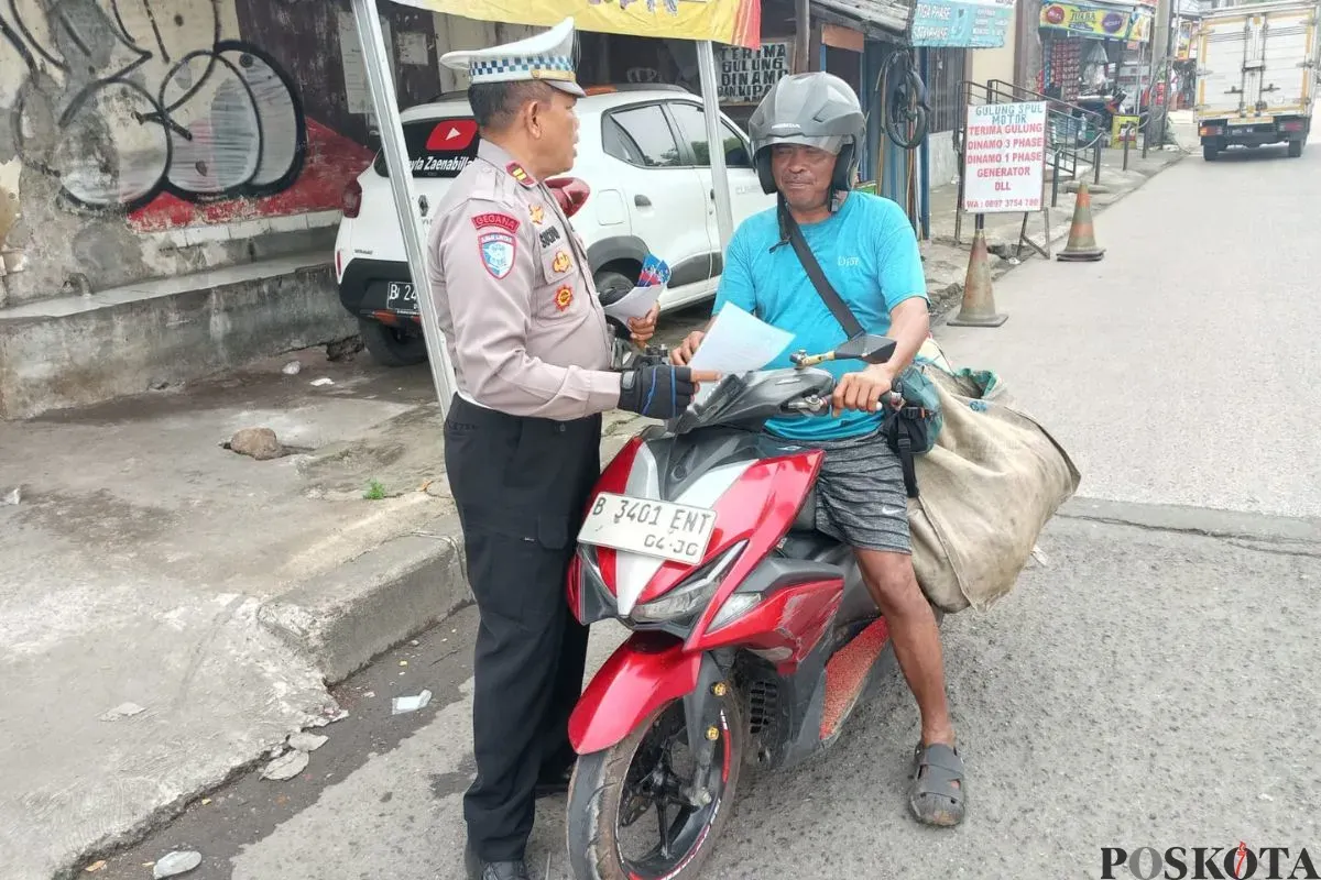 Kanit Lantas Polsek Cimanggis, Iptu Sucipto memberikan teguran kepada pengendara motor di Jalan Rajawali Samping Tol Cisalak, Cimanggis, Kota Depok, Senin, 14 Juli 2025. (Sumber: Poskota/Angga Pahlevi)