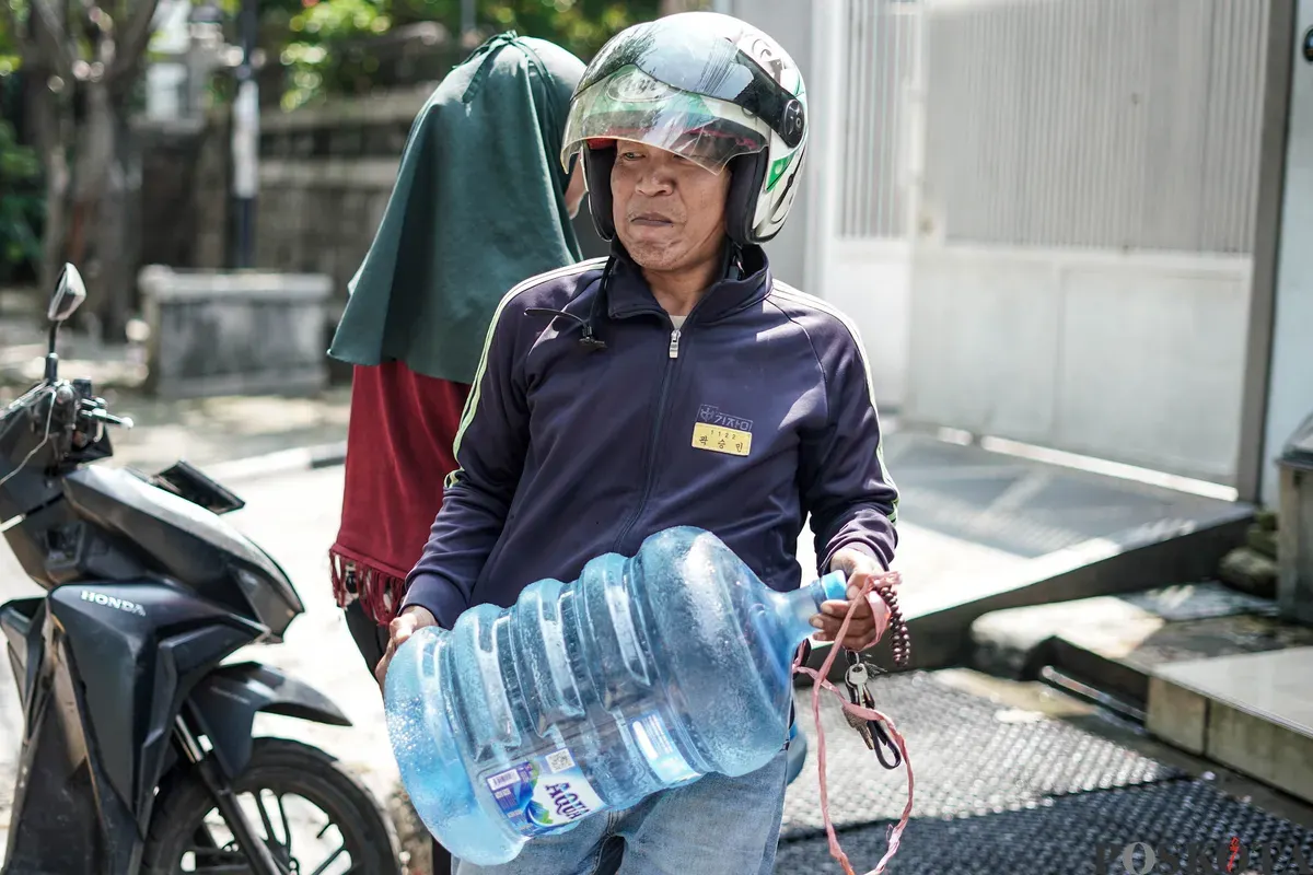 Warga mengisi botol air galon di depot air minum gratis di Jalan Rawamangun Muka Selatan, Jakarta Timur, Selasa, 15 Juli 2025. (Sumber: Poskota/Bilal Nugraha Ginanjar)