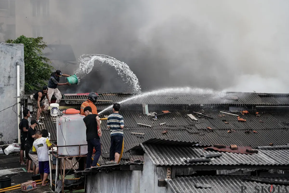 Petugas pemadam kebakaran memadamkan api yang membakar pemukiman padat penduduk di kawasan Grogol Utara, Kebayoran Lama, Jakarta Selatan, Minggu, 20 Juli 2025. (Sumber: Poskota/Bilal Nugraha Ginanjar)