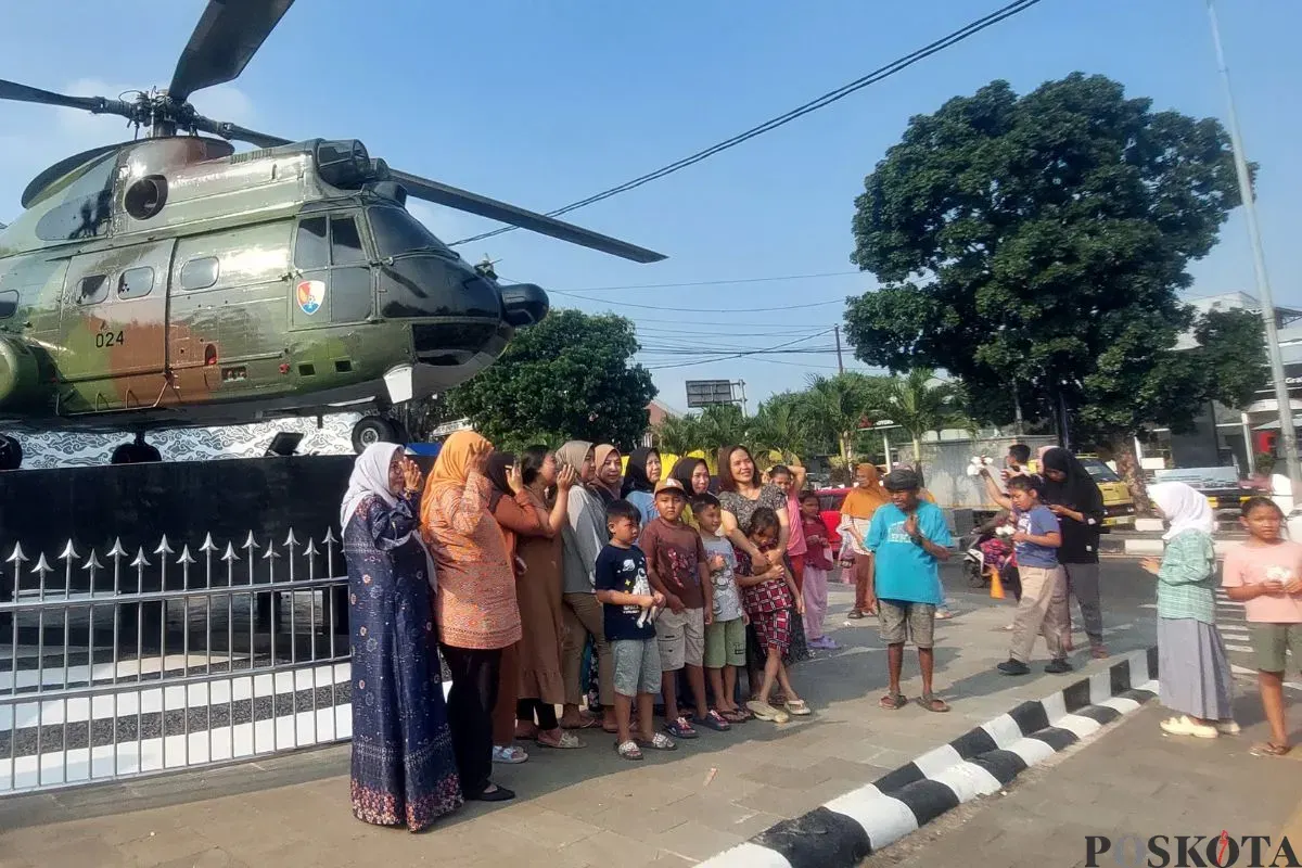 Momen warga mengabadikan diri di depan monumen Helikopter SA-330 Puma di kawasan Stadion Pakansari, Cibinong, Kabupaten Bogor, Jumat, 25 Juli 2025. (Sumber: Poskota/Sekar Putri Andini)