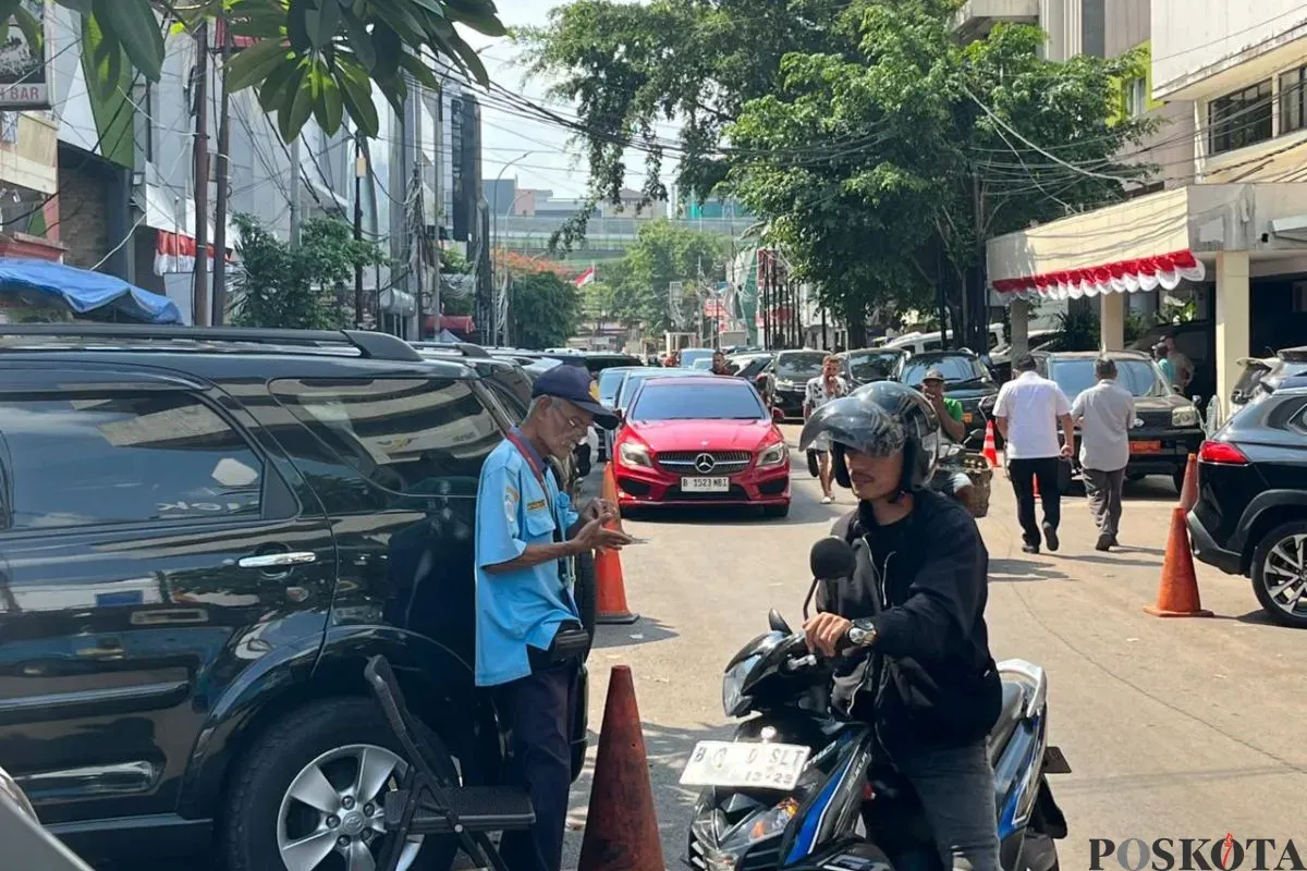 Salah seorang petugas parkir saat membantu pengendara mengeluarkan motornya di Jalan Palatehan I, Kebayoran Baru, Jakarta Selatan, Kamis, 31 Juli 2025. (Sumber: Poskota/Muhammad Tegar Jihad)