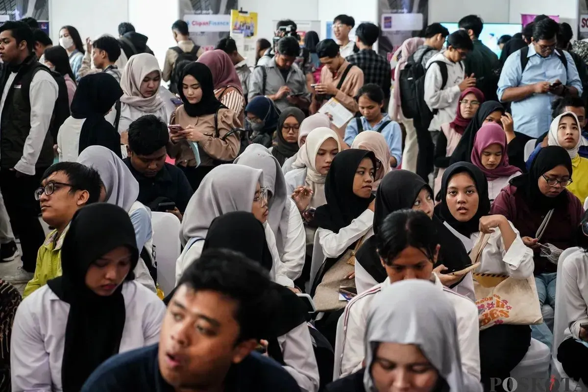 Pencari kerja melihat lowongan pekerjaan di salah satu stan perusahaan di GOR Kemayoran, Jakarta, Selasa, 6 Mei 2025. (Sumber: Poskota/Bilal Nugraha Ginanjar)