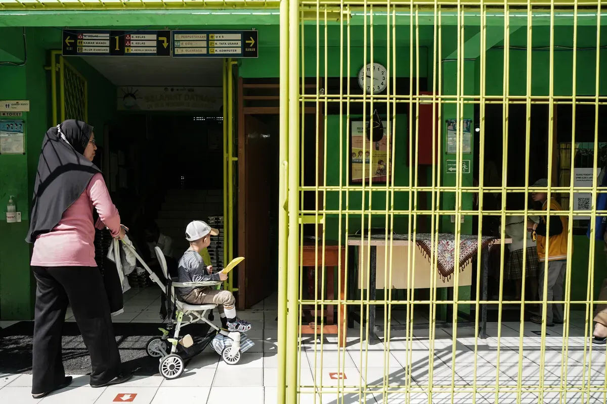 Orang tua siswa megantar anaknya untuk mendaftar sekolah di Posko Sistem Penerimaan Murid Baru (SPMB) SLB Negeri 5 Jakarta, Senin, 16 Juni 2025. (Sumber: Poskota/Bilal Nugraha Ginanjar)