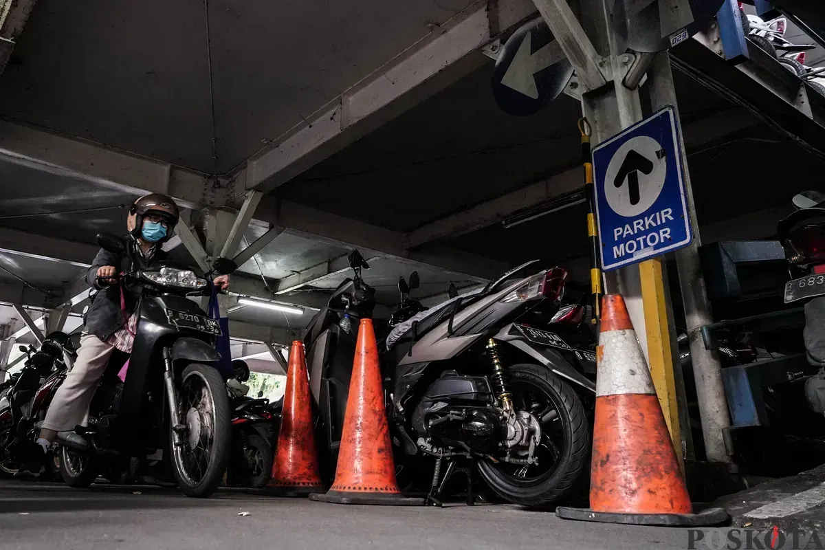 Pengendara mengeluarkan sepeda motor dari area parkir. (Sumber: Poskota/Bilal Nugraha Ginanjar)