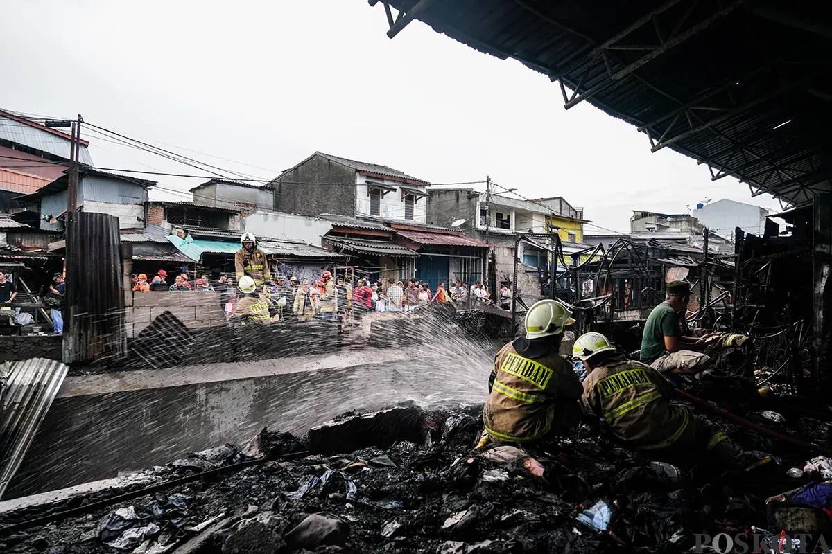 Petugas Penanggulangan Kebakaran dan Penyelamatan (Gulkarmat) Jakarta memadamkan sisa-sisa api saat proses pendinginan pasca musibah kebakaran di Pasar Poncol, Senen, Jakarta Pusat, Senin, 18 Maret 2025. (Sumber: Poskoata/ Bilal Nugraha Ginanjar)