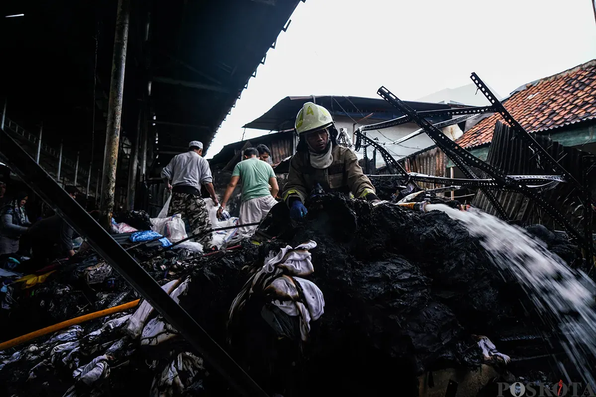 Petugas Penanggulangan Kebakaran dan Penyelamatan (Gulkarmat) Jakarta memadamkan sisa-sisa api saat proses pendinginan pasca musibah kebakaran di Pasar Poncol, Senen, Jakarta Pusat, Senin, 18 Maret 2025. (Sumber: Poskoata/ Bilal Nugraha Ginanjar)