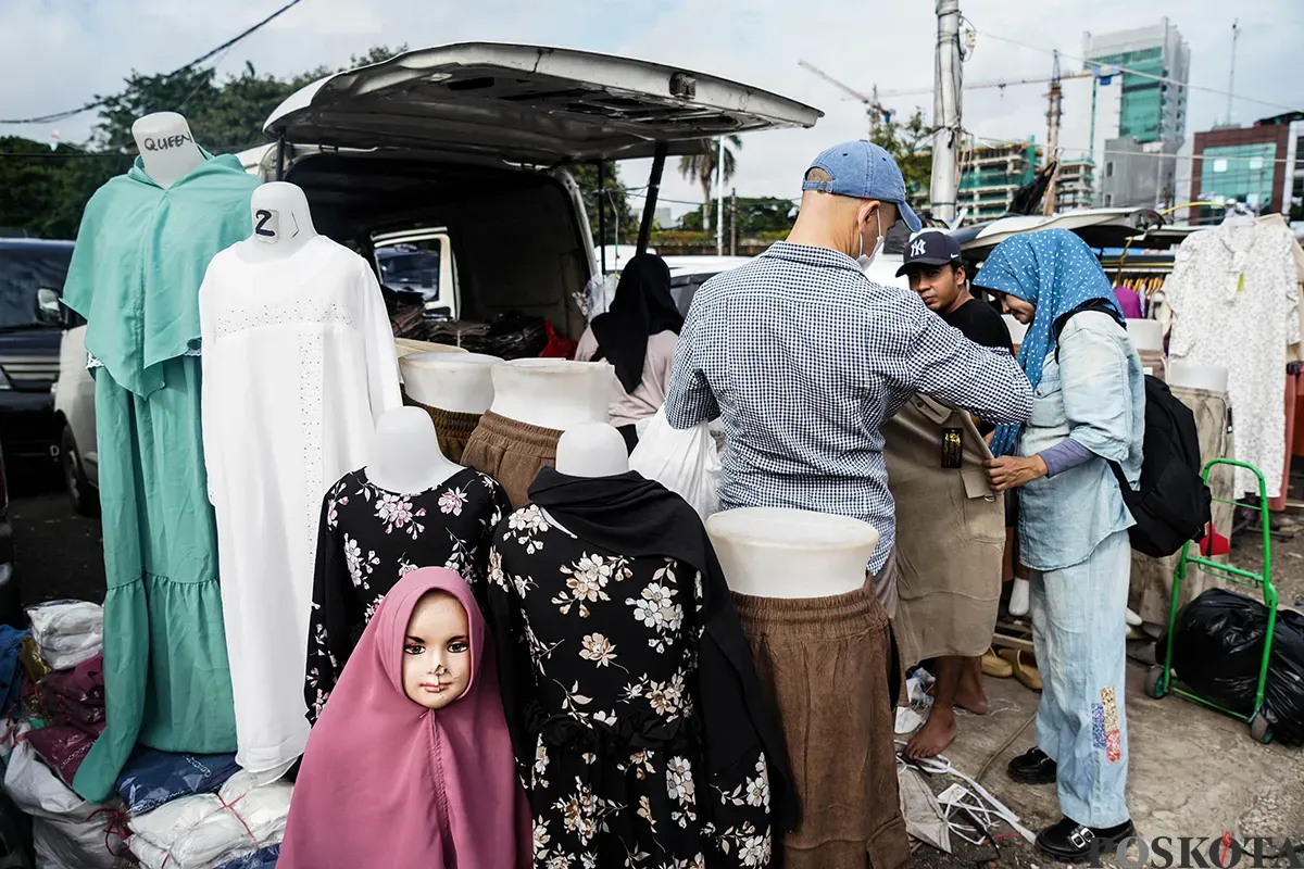 Pedagang melayani calon pembeli saat  memilih ragam busana lebaran di Pasar Tasik, Cideng, Jakarta Pusat, Kamis 20 Maret 2025. (Sumber: Poskoata/ Bilal Nugraha Ginanjar)