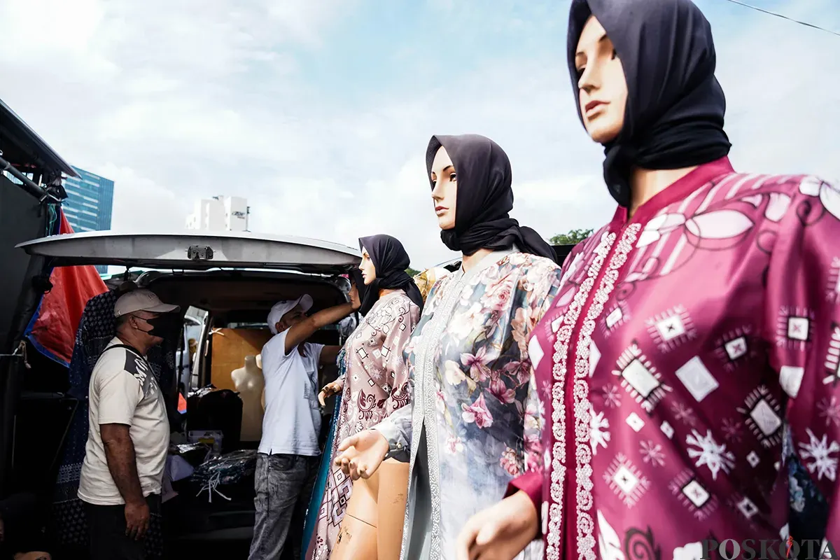 Pedagang melayani calon pembeli saat  memilih ragam busana lebaran di Pasar Tasik, Cideng, Jakarta Pusat, Kamis 20 Maret 2025. (Sumber: Poskoata/ Bilal Nugraha Ginanjar)