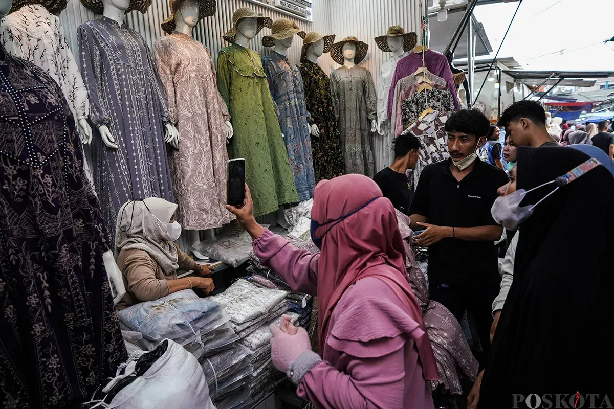 Pedagang melayani calon pembeli saat  memilih ragam busana lebaran di Pasar Tasik, Cideng, Jakarta Pusat, Kamis 20 Maret 2025. (Sumber: Poskoata/ Bilal Nugraha Ginanjar)